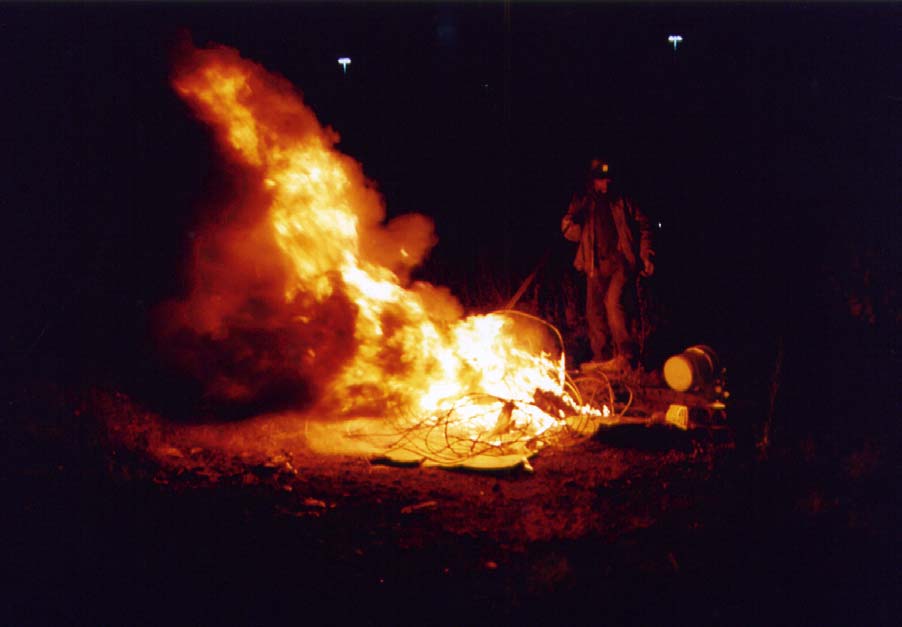 Scrapper "Country" burning the plastic coating off of copper cable.